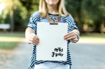 woman in blue and white long sleeve shirt holding white book