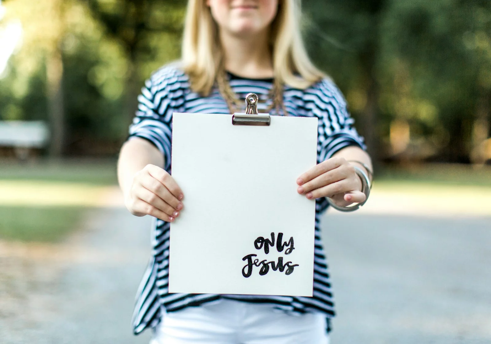 woman in blue and white long sleeve shirt holding white book