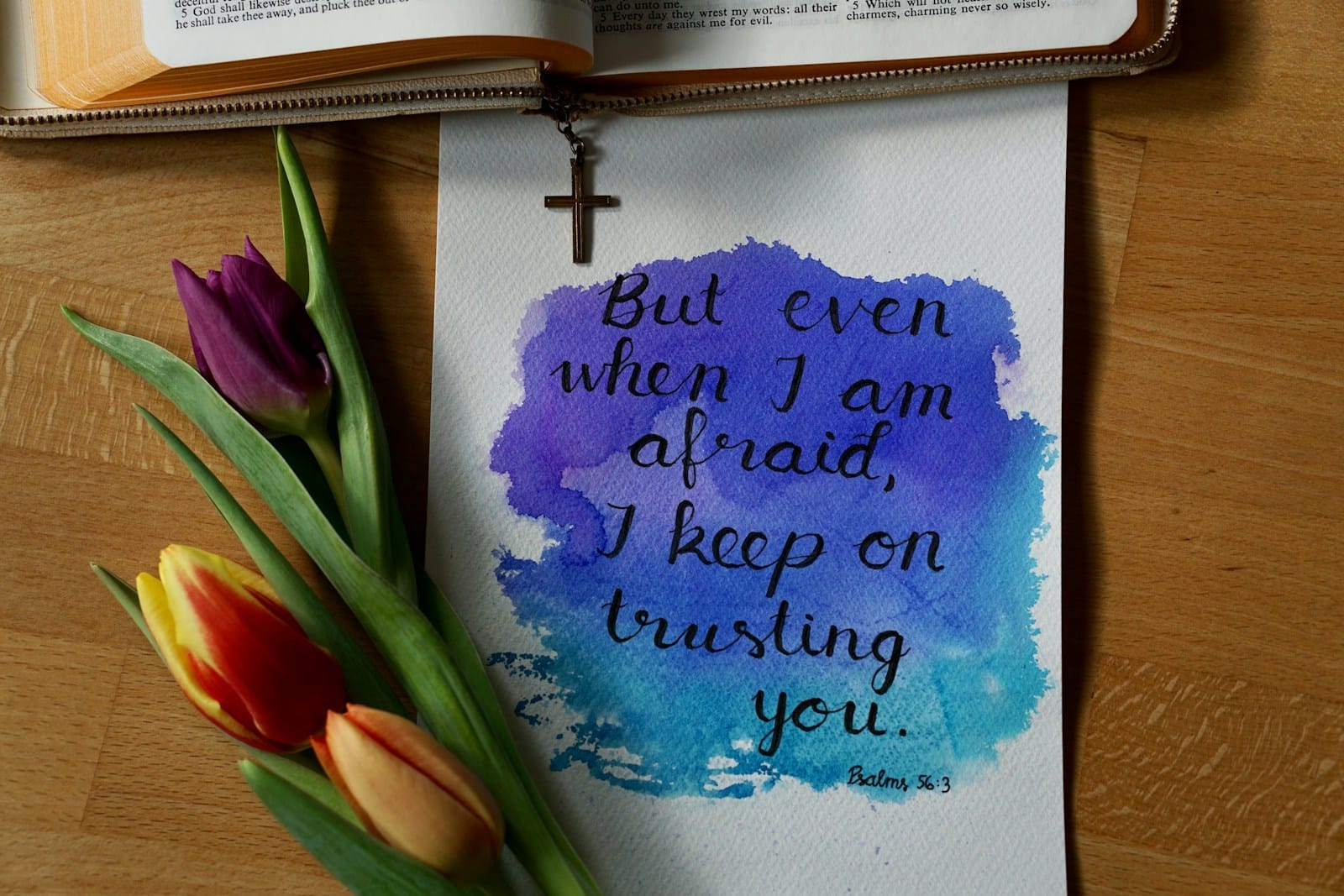 a watercolor painting of a bible and a flower